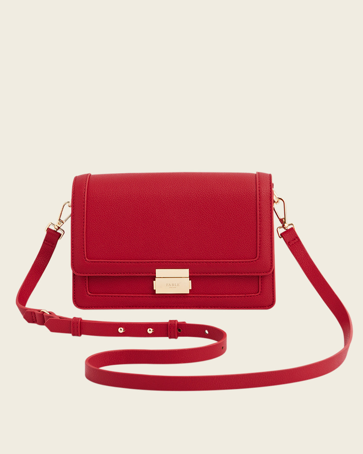Red handbag with a gold clasp on a beige background