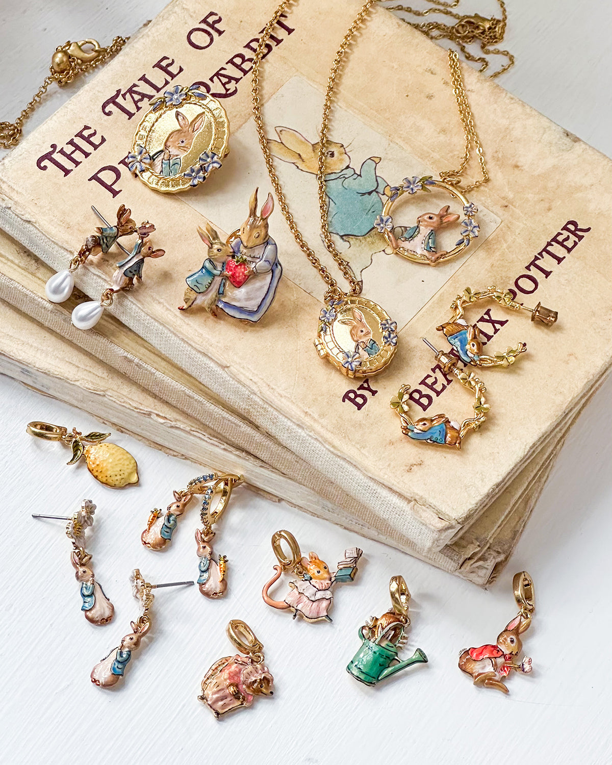 Jewelry set with characters from 'The Tale of Peter Rabbit' by Beatrix Potter on an old book.