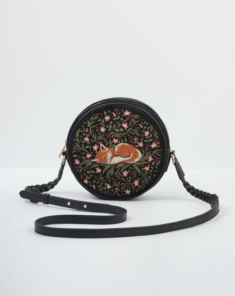 embroidered sleepy fox motif on navy circle crossbody bag.