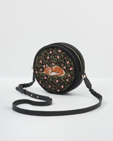 Angle of embroidered sleepy fox motif on navy circle crossbody bag.