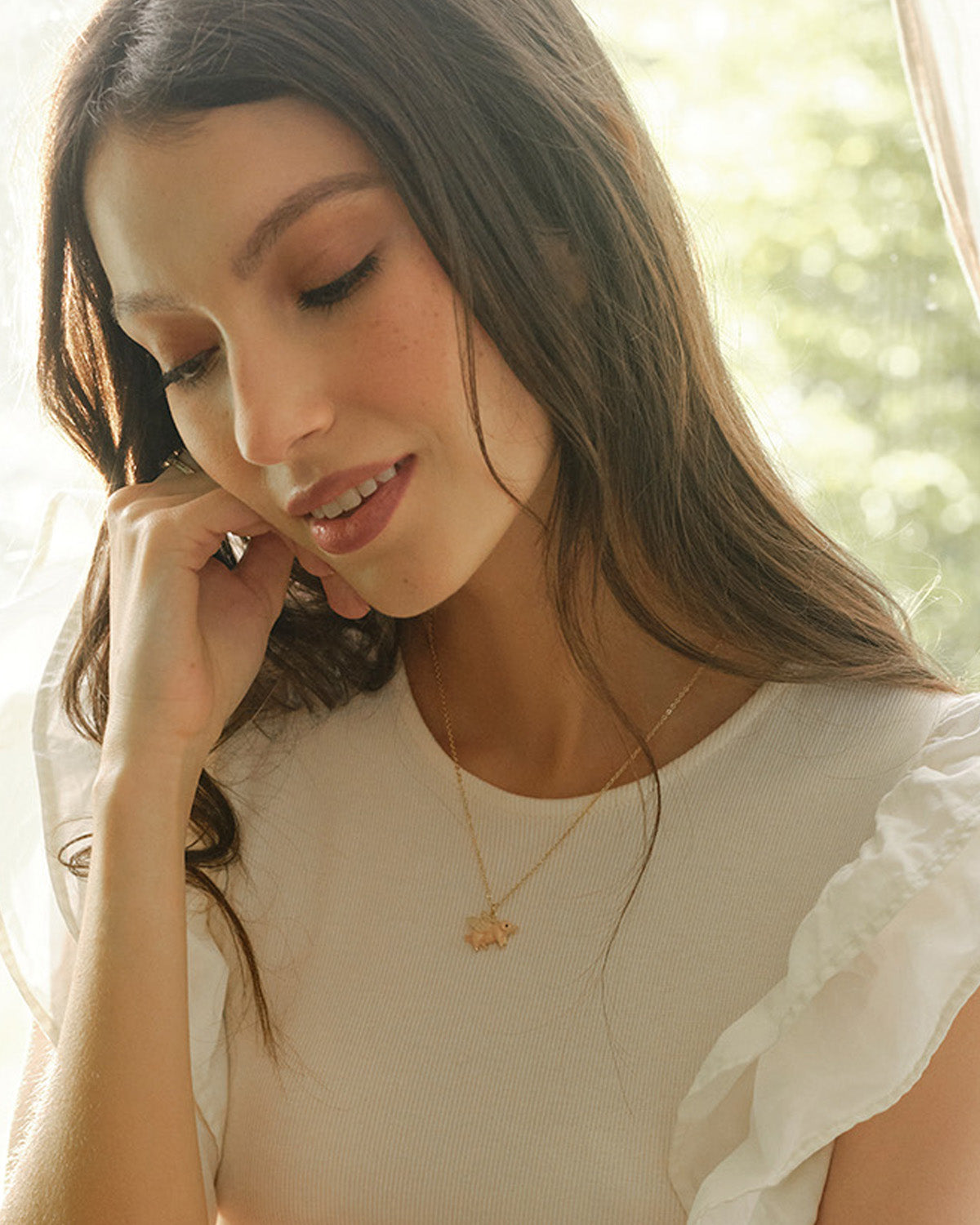 woman wearing flying pig pendant necklace on gold fine chain