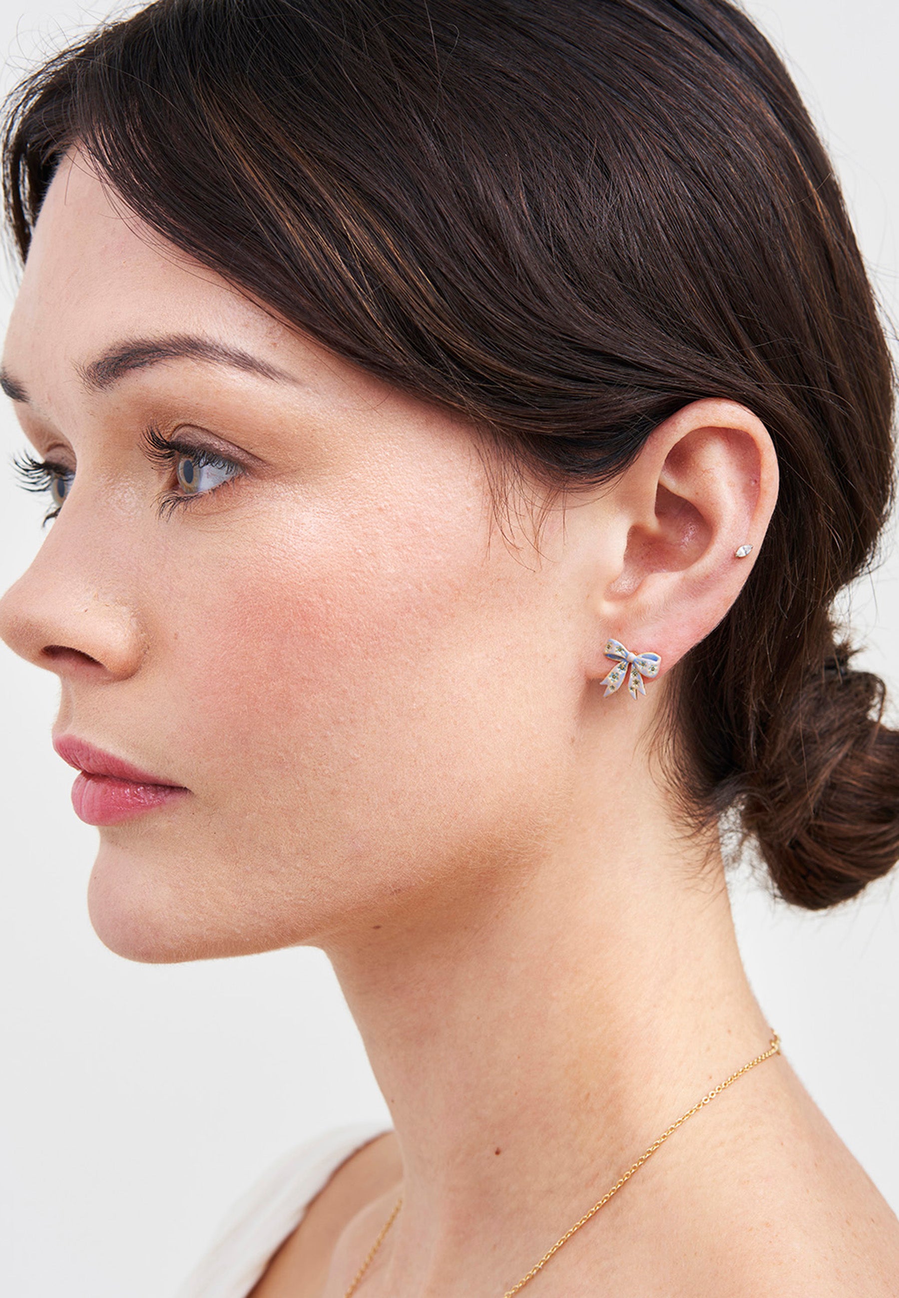 Gold Forget Me Not Bow Stud Earrings on a woman